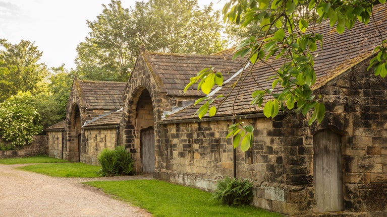 A dark stone building with large arched doorways